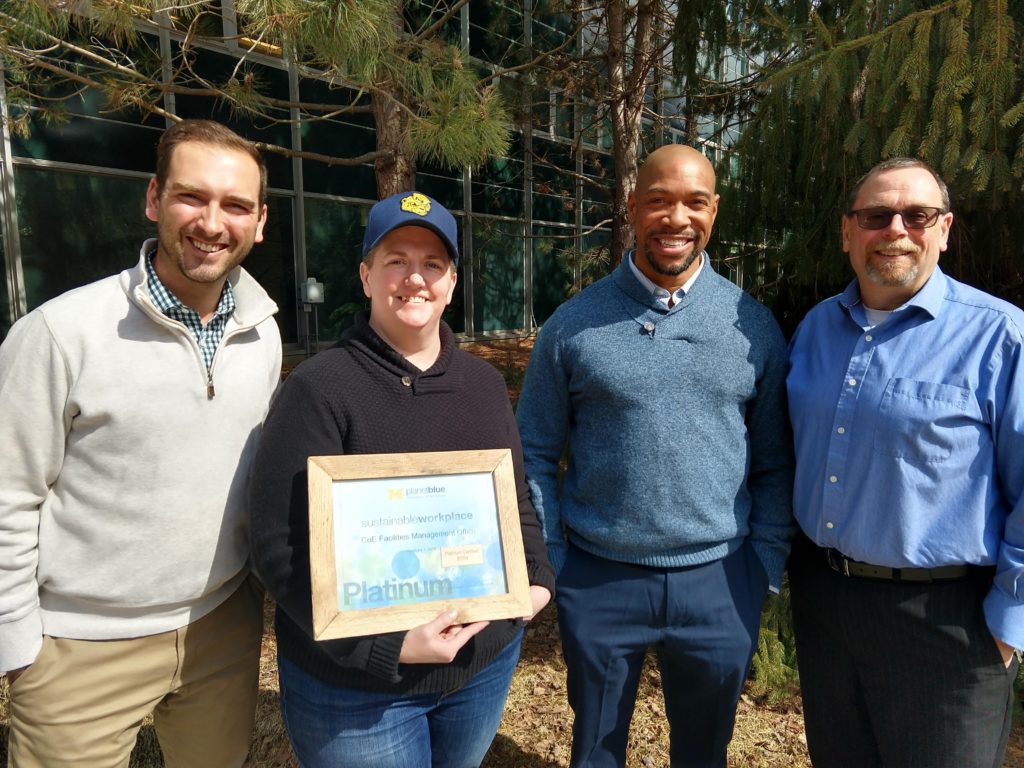 Four people posting with a platinum recertification for CoE Facilities